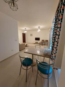 a dining room with a table and chairs and a living room at Marina Residence New Alamein 2 bedroom apartment in El Alamein