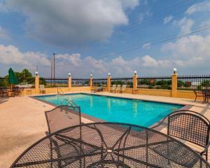 a swimming pool with two chairs in front of it at Comfort Suites Lake Ray Hubbard in Rowlett