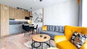 a living room with a couch and a table at Apartamenty Sun & Snow Stone Hill in Szklarska Poręba