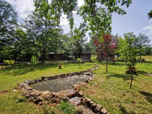 a pond in the middle of a yard with trees at Etno Selo Dodig in Drvar