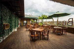 a restaurant with tables and chairs and an umbrella at Best Inn Balikpapan in Balikpapan