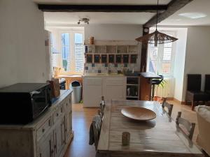 a kitchen with a wooden table and a dining room at Yvana in Concarneau
