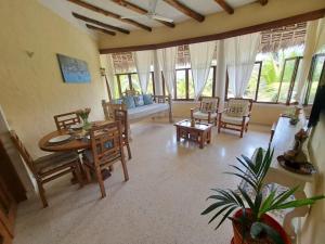 - un salon avec une table, des chaises et un canapé dans l'établissement Tembo Beach Cottage, à Malindi
