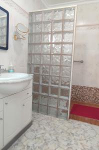 uma casa de banho com um lavatório e um chuveiro com prateleiras de vidro em Mar y Sol 7 with sea views em Punta Mujeres