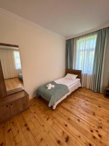 a bedroom with a bed and a large window at Polaris Kazbegi in Kazbegi