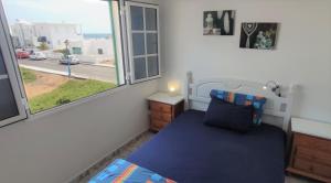 um quarto com uma cama azul e uma janela em Mar y Sol 7 with sea views em Punta Mujeres