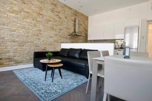 un salon avec un canapé noir et une table dans l'établissement Premium Apartment by Hi5- Anker Apartment, à Budapest