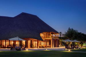 منتجع نوفا الرياض، راديسون كوليكشن في Ţibrāk: منتجع ذو مبنى كبير به طاولات ومظلات