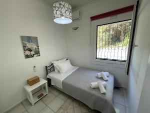 um pequeno quarto com uma cama e uma janela em Villa Penelope em Corfu Town