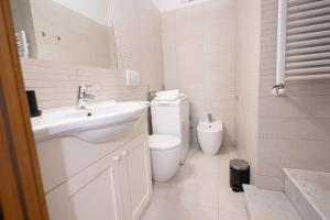 a white bathroom with a sink and a toilet at Ibernesi 23 - Fori Imperiali in Rome +22 photos