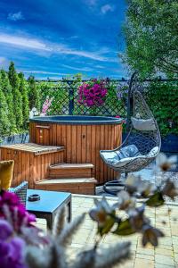 een patio met een stoel en een zwembad bij Domek w górach - Prywatne Jacuzzi, Sauna, Grota Solna - PANORAMA CHEŁM SKI&SPA in Myślenice