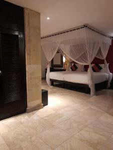 a bedroom with two white beds with mosquito nets at The Royal Beach Seminyak Bali in Seminyak