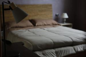 1 dormitorio con 1 cama con lámpara junto a una mesa en 10 minutes to flight Orio al Serio BGY, en Zanica