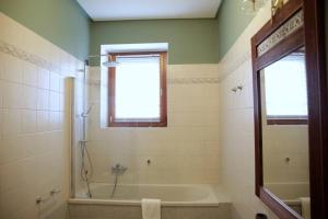a bathroom with a tub and a shower with a window at 10 minutes to flight Orio al Serio BGY in Zanica +11 photos