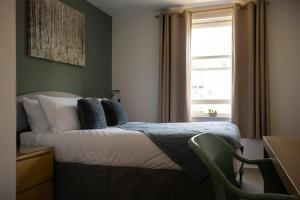 1 dormitorio con 1 cama con ventana y silla en Spacious 3 bedroom apartment free parking en Kent