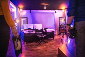 a person standing in a purple room with a bed at Anybody - Awarded love hotel in Brno