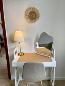 a desk with a lamp and a chair on it at Perfekt für 5 - Stylisch & Zentral - Küche in Essen
