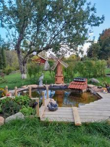 un estanque en un jardín con un molino de viento en Mysig stuga nära havet och naturreservat, en Jomala