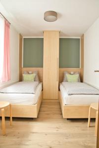 two twin beds in a room with wooden floors at Landurlaub in Schmallenberg Landstübchen in Schmallenberg