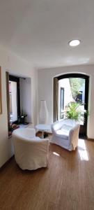 una sala de estar con 2 sofás blancos y una ventana grande en HOSTEL NAMOR en Ribadeo
