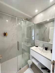a bathroom with a glass shower and a sink at Le Royal Picardie in Albert