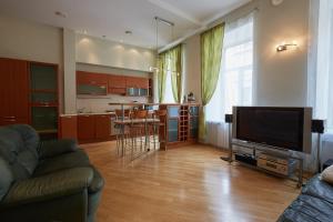 a living room with a couch and a television at Center City Flats Central Saint Petersburg in Saint Petersburg