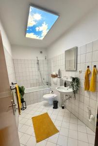 a bathroom with a toilet and a sink and a skylight at Perfekt für 5 - Stylisch & Zentral - Küche in Essen