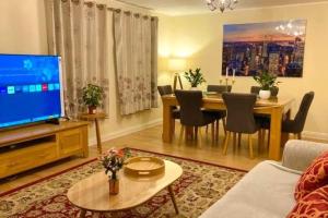 a living room with a dining table and a television at 2 Bedroom Flat in Ardwick Manchester in Manchester