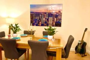 a dining room table with chairs and a painting on the wall at 2 Bedroom Flat in Ardwick Manchester in Manchester