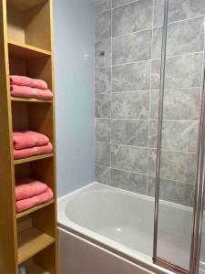 een badkamer met een douche en roze handdoeken bij 2 Bedroom Flat in Ardwick Manchester in Manchester