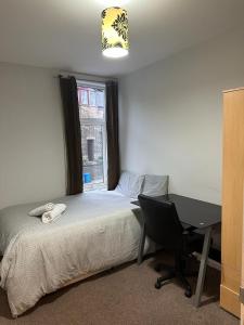a bedroom with a bed and a desk and a window at Ecclesall Suites in Nether Edge