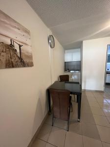 a dining room with a table and a kitchen at Santa Lucia Apartments in Bodensdorf