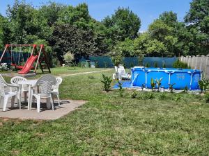 a yard with a table and chairs and a playground at Alexander apartman in Gyula