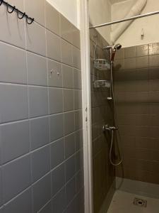 y baño con ducha y azulejos grises. en Sosnowy Village Hel Helska 11 en Hel