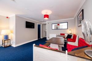 a living room with a red couch and a table at New Town Rooms in Edinburgh