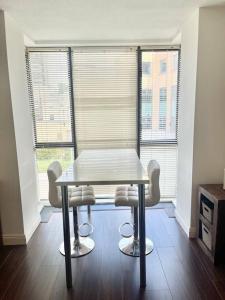 una mesa y sillas en una habitación con ventanas en Quiet, Luxury Apt in Dublin. en Dublín