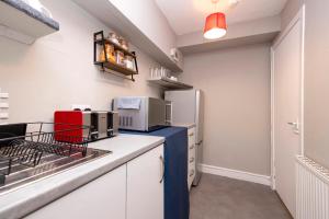 a kitchen with a sink and a refrigerator at New Town Rooms in Edinburgh