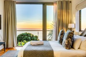 a bedroom with a bed with a view of the ocean at Lobster Villa in Cape Town