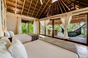a bedroom with two beds and a large window at Hotel CasaBakal - A pie de Laguna - Bacalar in Bacalar