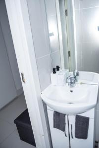 a bathroom with a white sink and a mirror at 1B Apartment, 30 mins to Oxford Street in London