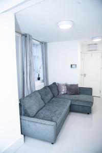 a living room with a blue couch in a white room at 1B Apartment, 30 mins to Oxford Street in London