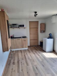 een keuken met houten vloeren en een witte koelkast bij Le Marronnier in Billy