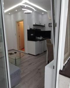 Apartmani Banja Vrujci Lux في Gornja Toplica: غرفة معيشة مع طاولة زجاجية وغرفة