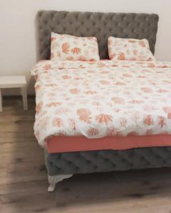 ein Schlafzimmer mit einem Bett mit rosa Blumen drauf in der Unterkunft Apartmani Banja Vrujci Lux in Gornja Toplica