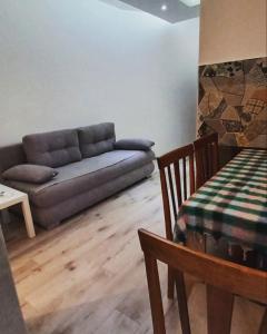 ein Wohnzimmer mit einem Sofa und einem Tisch in der Unterkunft Apartmani Banja Vrujci Lux in Gornja Toplica