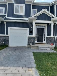 a blue house with a white garage at Deluxe 3 Bedroom near Hyde Park mall & Western Uni in London