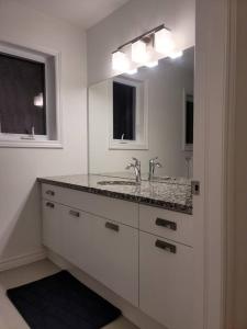 a white bathroom with a sink and a mirror at Deluxe 3 Bedroom near Hyde Park mall & Western Uni in London