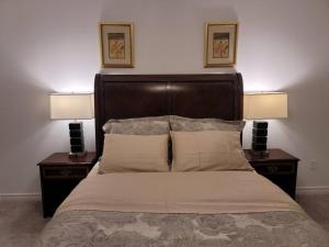 a bedroom with a bed with two nightstands and two lamps at Deluxe 3 Bedroom near Hyde Park mall & Western Uni in London