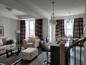 a living room with a kitchen and a living room with a table at Deluxe 3 Bedroom near Hyde Park mall & Western Uni in London
