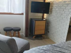 a bedroom with a tv on a brick wall at La Marjolaine in Annecy